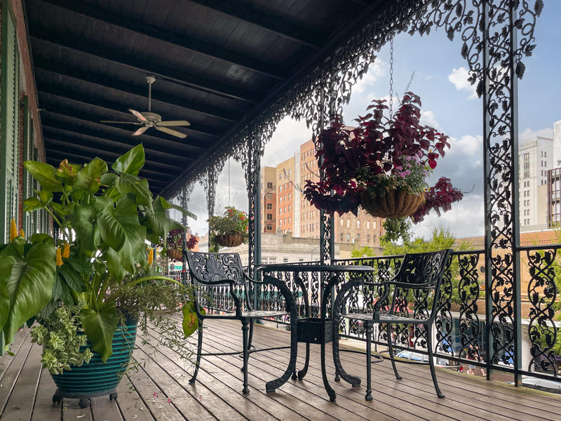 a patio with chairs and a table and a planter
