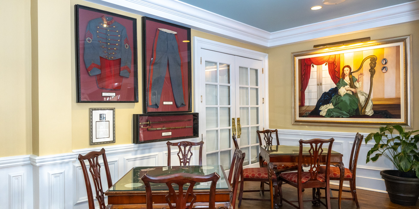 a room with a table and chairs and a framed picture on the wall