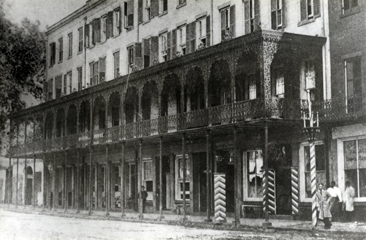 An old photograph of the Marshall House from the 1870s, prominently featuring its iconic cast-iron veranda