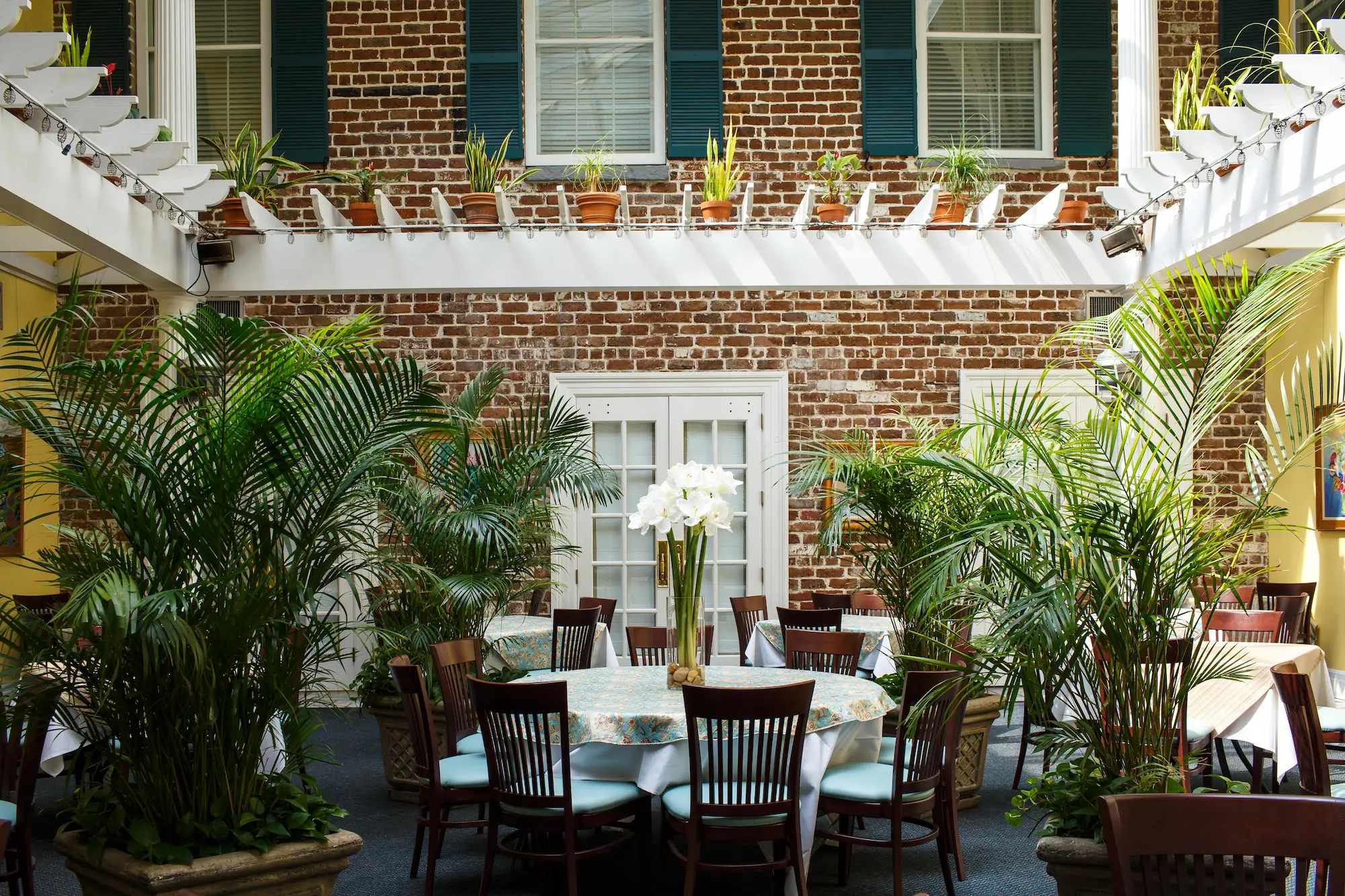tables surrounded by greenery in the atrium at the Marshall House in Savannah Georgia