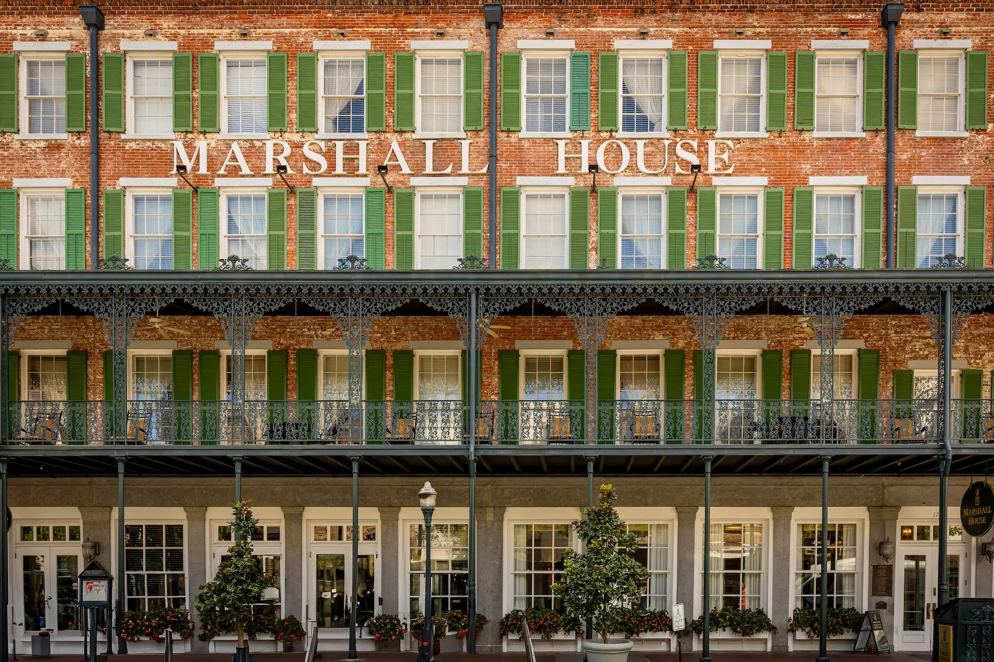 the exterior of the Marshall House in Savannah, Georgia, with prominent signage mounted on the brickwork