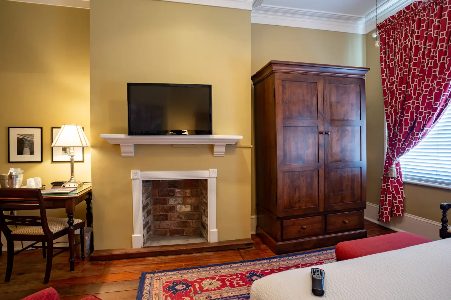 desk, TV, fireplace, and armoire in the superior king room at the Marshall House hotel