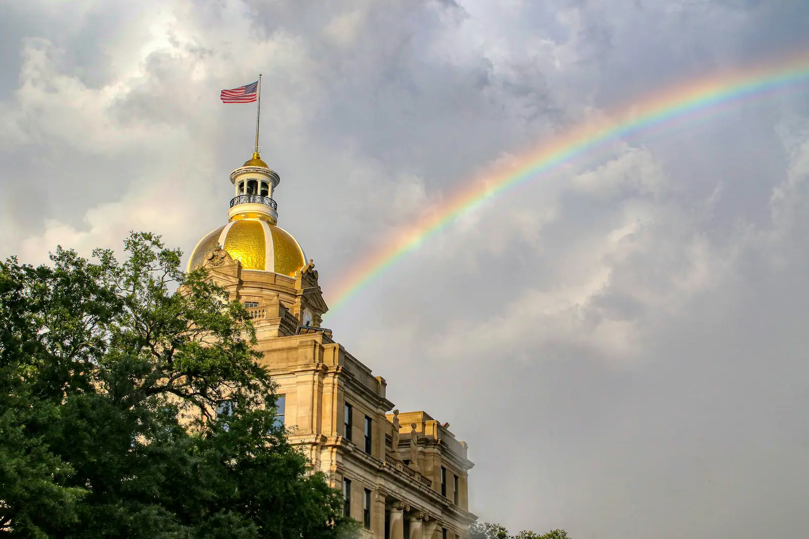 A rainbow arcs across the sky behind City Hall in Savannah, Georgia